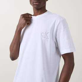 Model wearing Calvin Klein Jeans Monogram Logo T-Shirt in Bright White, crew neck with short sleeves and embroidered CK chest logo