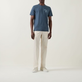 Model wearing Calvin Klein Jeans Travel Line Logo T-Shirt in Dark Slate with cream chinos and white trainers.