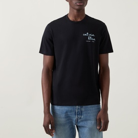 Model wearing Calvin Klein Jeans Travel Line Logo T-Shirt in black, crew neck with chest logo print, styled with light blue jeans.