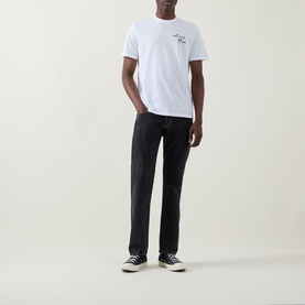 Model wearing Calvin Klein Jeans Travel Line Logo T-Shirt in Bright White with black jeans and black trainers