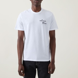 Model wearing Calvin Klein Jeans Travel Line Logo T-Shirt in Bright White with crew neck and chest logo, styled with dark jeans