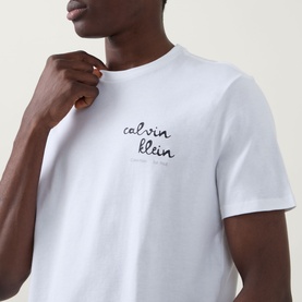 Model wearing Calvin Klein Jeans Travel Line Logo T-Shirt in Bright White, close-up showing embroidered script logo on chest