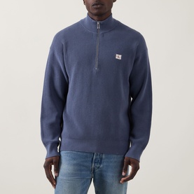 Model wearing Calvin Klein Jeans Waffle-Knit Logo Half-Zip Sweatshirt in Blue Nomad, styled with light-wash jeans.