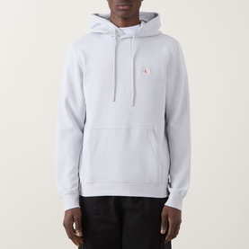 Model wearing Calvin Klein Jeans Monogram Badge Drawstring Hoodie in Marble Grey, with kangaroo pocket and small logo badge, styled with black