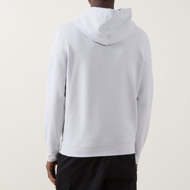 Model wearing Calvin Klein Jeans Monogram Badge Drawstring Hoodie in Marble Grey, back view, with black joggers.