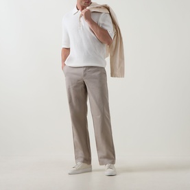 Model wearing Calvin Klein Jeans Waffle-Knit Logo Polo Shirt in Tofu with stone chinos and white trainers