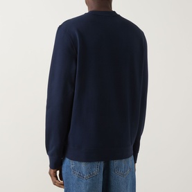 Model wearing Calvin Klein Jeans Monogram Logo Sweatshirt in black, crew neck with ribbed trims, back view, styled with blue jeans