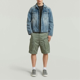 Model wearing G-Star LT Orphus cargo shorts in sage green, styled with a washed blue denim jacket and grey trainers.