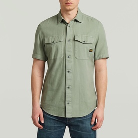 Model wearing G-Star Slim Shirt in light sage green, short sleeves, twin chest pockets with button flap, styled with blue jeans