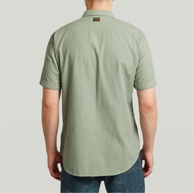 Model wearing G-Star Slim Shirt in light green, shown from behind, with short sleeves and logo patch at collar, styled with blue jeans