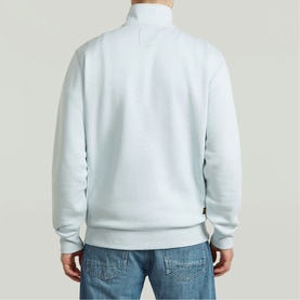 Model wearing G-Star baby blue quarter-zip sweatshirt, back view, styled with light-wash denim jeans