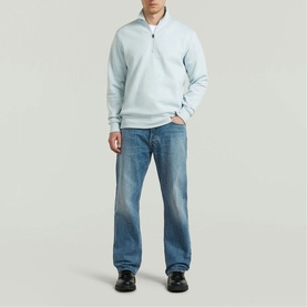 Model wearing G-Star baby blue quarter-zip sweatshirt, styled with light wash straight-leg jeans and black shoes