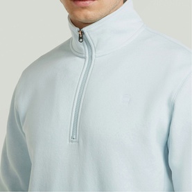 Model wearing G-Star baby blue quarter-zip sweatshirt with silver-tone zip and small logo embroidery at chest.