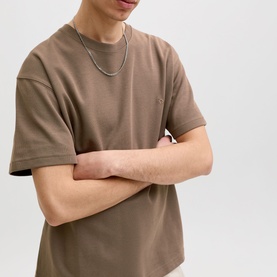 Model wearing Jack & Jones Morel Crew Neck T-shirt with arms crossed, styled with a silver chain necklace