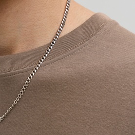 Model wearing Jack & Jones Morel crew neck T-shirt, close-up of neckline with silver chain necklace styled over top.