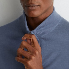 Model wearing Reiss airforce blue quarter-zip knit sweater, close-up of zip detail at neckline
