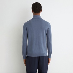 Model wearing Reiss airforce blue roll-neck knit sweater, back view, styled with navy trousers.