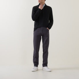 Model wearing Meyer grey cotton-elastane trousers with a black knit jumper and white trainers