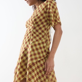 Model wearing Damson Madder Harmony Gingham Mini Dress in multi yellow and red check, short sleeves, ruffle details, cinched waist.