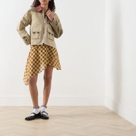 Model wearing Damson Madder Marcelle Reversible Barn Jacket in multi, styled with yellow gingham mini skirt and black loafers.
