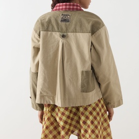 Model wearing Damson Madder Marcelle Reversible Barn Jacket in Multi, back view showing inverted pleat, patch pocket, styled with check shirt and