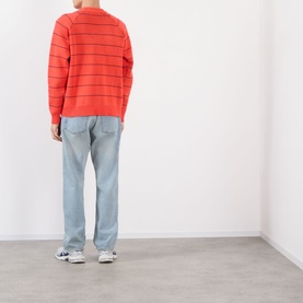 Model wearing Pellador Stripe Logo Sweater in red with navy stripes, crew neck, styled with light blue jeans and grey trainers.