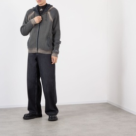 Model wearing Pellador Rib Knit Hoodie in grey with zip fastening and seam details, styled with black wide-leg trousers and black shoes.