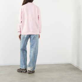 Model wearing Pellador Logo Mesh Football Training Top in pink, back view, styled with light-wash wide-leg jeans and dark chunky trainers.