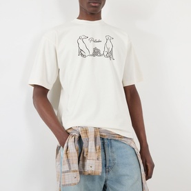 Model wearing Pellador Dog Tail Knot Logo T-Shirt in white with dog motif graphic, styled with light-wash jeans and plaid shirt tied at waist.