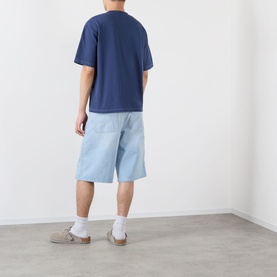 Model wearing Pellador Roundstone Logo T-Shirt in navy, styled with light wash denim shorts and grey suede shoes.