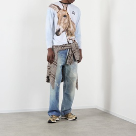 Model wearing Pellador Donkey Paint Graphic Long-Sleeved T-Shirt in print, styled with distressed wide-leg jeans, layered shirt, and chunky trainers.