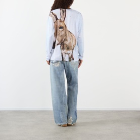 Model wearing Pellador Donkey Paint Graphic Long-Sleeved T-Shirt in print, styled with light wash wide-leg jeans, back view.