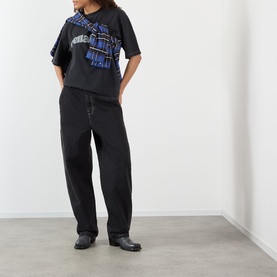 Model wearing Pellador Logo Print T-Shirt in black with blue graphic print, styled with black wide-leg trousers and black leather shoes.