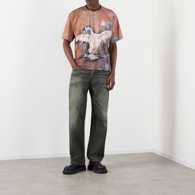 Model wearing Pellador Swan Graphic T-Shirt in print, styled with dark olive distressed jeans and black chunky loafers.