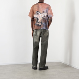 Model wearing Pellador Swan Graphic T-Shirt in print, rear view showing swan motif, styled with dark green distressed trousers.
