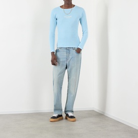 Model wearing Pellador Waffle Logo Long-Sleeve T-Shirt in Baby Blue with light-wash jeans and black trainers.