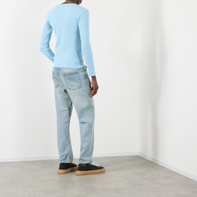 Model wearing Pellador Waffle Logo Long-Sleeve T-Shirt in Baby Blue, styled with light wash jeans and dark trainers, rear view.