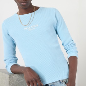 Model wearing Pellador Waffle Logo Long-Sleeve T-Shirt in baby blue with round neckline and front logo print, styled with gold chain necklace.