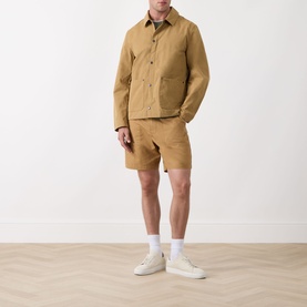 Model wearing Barbour Bayfield Logo Overshirt in Camel with matching shorts and white trainers.