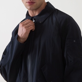 Model wearing Barbour dark navy casual jacket, zip-up with shirt collar detail, close-up showing chest and sleeve