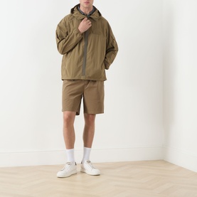 Model wearing Barbour Clay casual hooded jacket, styled with matching shorts and white trainers