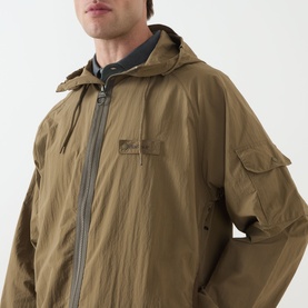Model wearing Barbour clay casual jacket in polyamide, hooded with zip front, chest patch pocket and sleeve utility pocket detail.