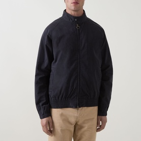 Model wearing Barbour navy cotton casual jacket with zip front, ribbed cuffs and hem, styled with beige chinos