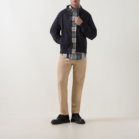 Model wearing Barbour navy cotton casual jacket, styled with grey check shirt, beige chinos and black leather shoes.