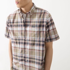 Model wearing Barbour Baycliff Logo Check Print Shirt in Burnt Pepper, short sleeves, button-down collar, chest patch pocket with logo badge.
