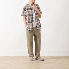 Model wearing Barbour Baycliff Logo Check Print Shirt in Burnt Pepper, styled with khaki trousers and grey trainers.