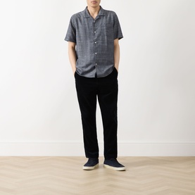 Model wearing Barbour Bowston Patch Pocket Logo Shirt in Dark Navy, camp collar, short sleeves, styled with black trousers and navy slip-on shoes.