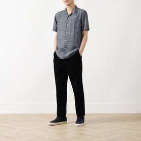 Model wearing Barbour Bowston Patch Pocket Logo Shirt in Dark Navy, short sleeves, camp collar, styled with black trousers and navy shoes.