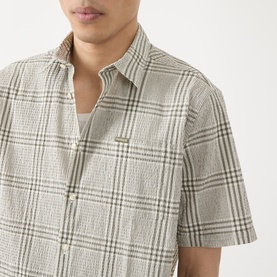 Model wearing Barbour Carrock Seersucker Check Print Shirt in Whisper White, short sleeves, point collar, check pattern with textured finish.