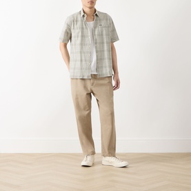 Model wearing Barbour Carrock Seersucker Check Print Shirt in Whisper White with beige trousers and white trainers.